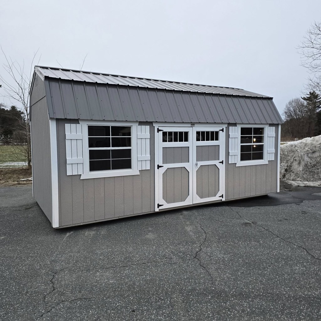 A side lofted barn at a sales lot with sheds for sale