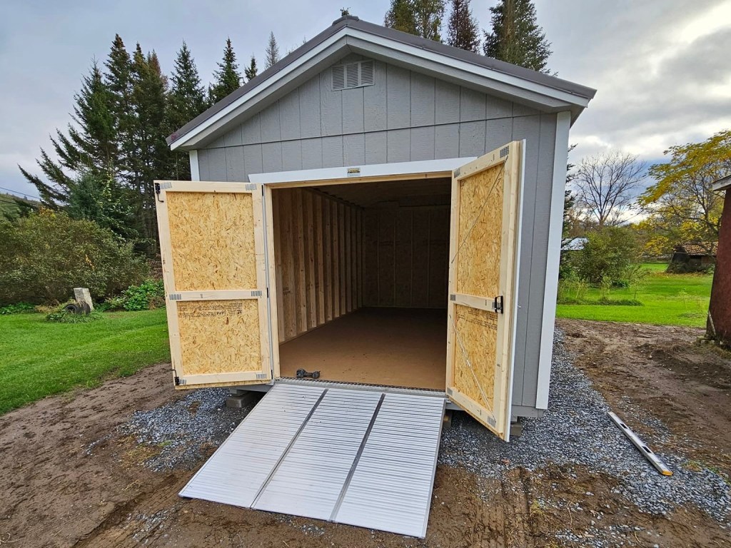 Aluminum shed ramps installed on a utility shed